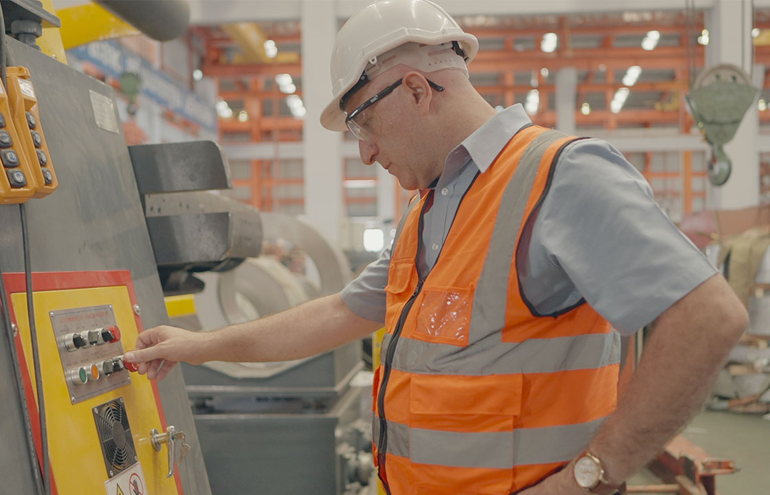 Man-in-hard-hat-inspecting-machinery