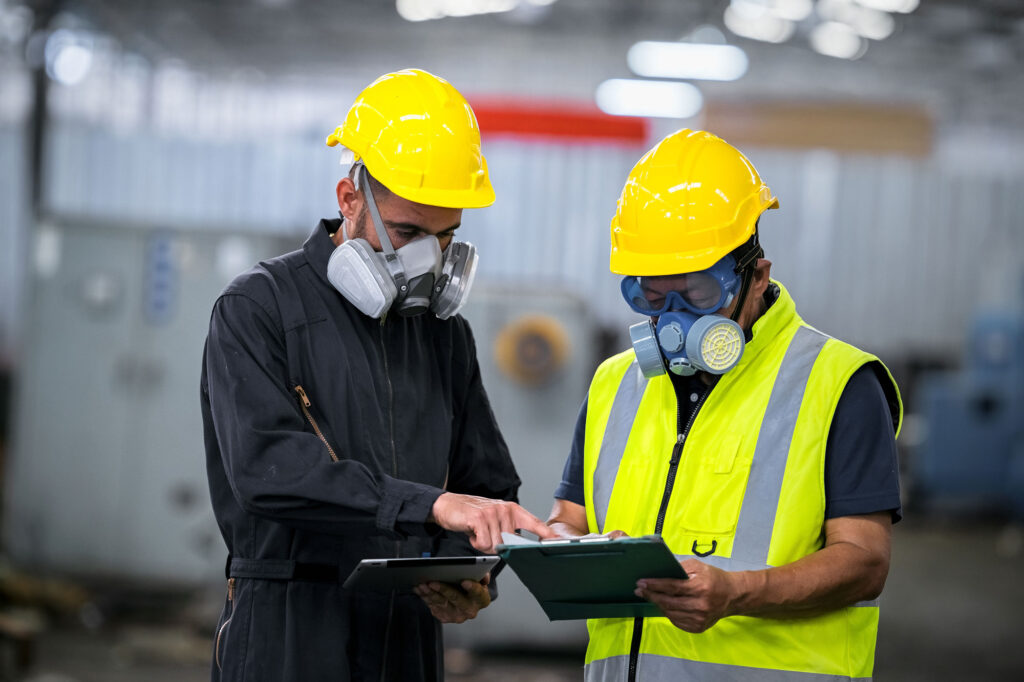 two EHS workers wearing PPE and protecting themselves against hazardous chemicals