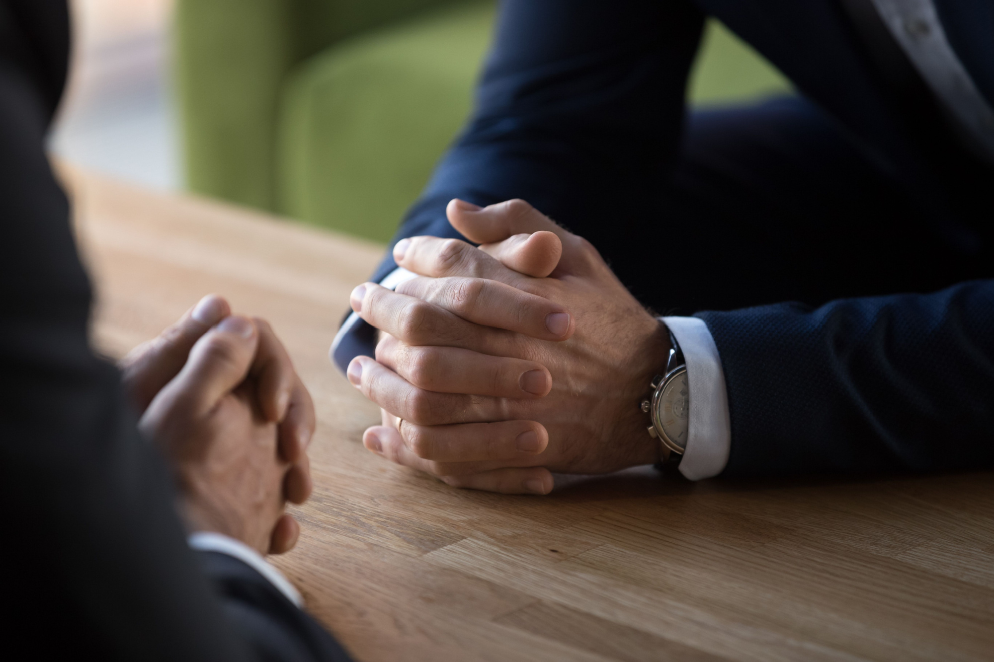 person at desk having a conversation with hands folded