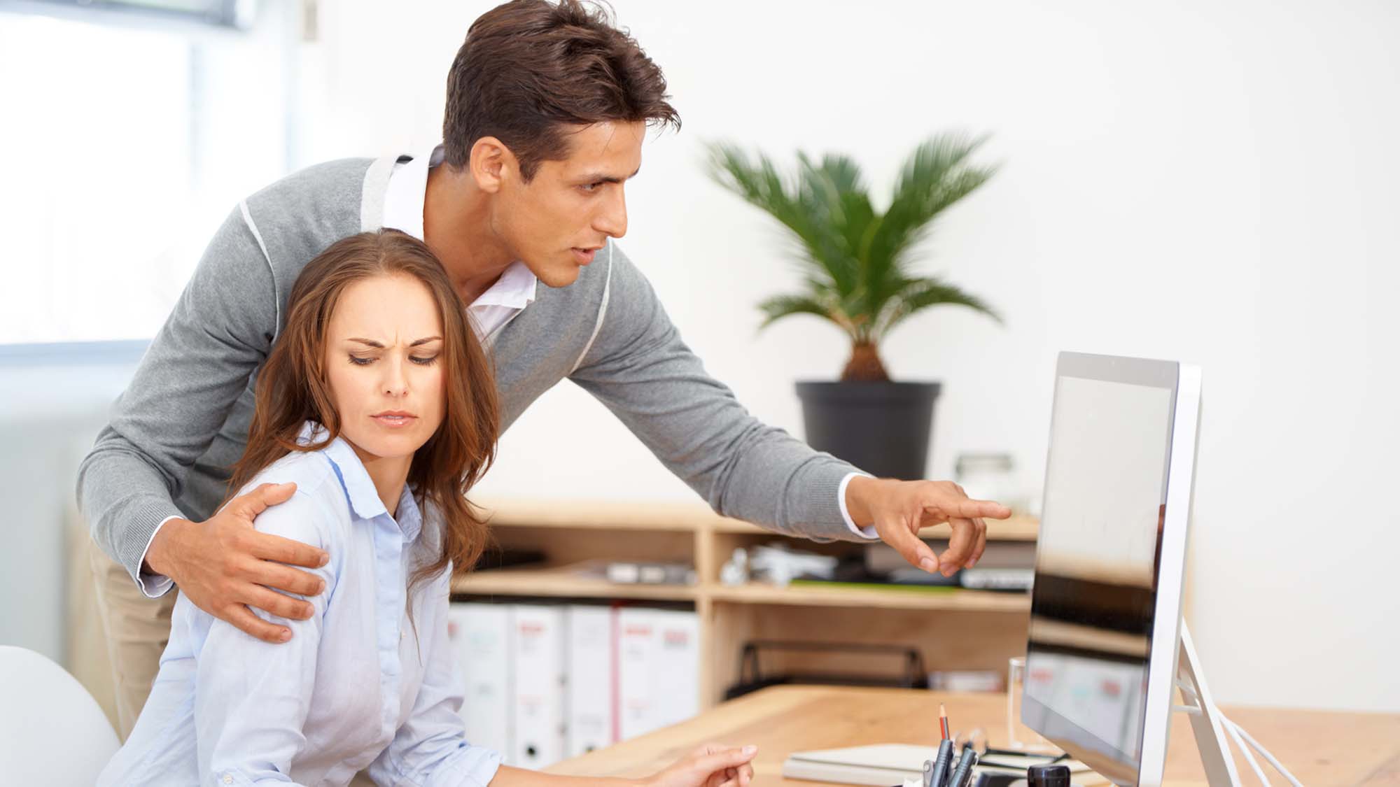 man standing over woman at her desk