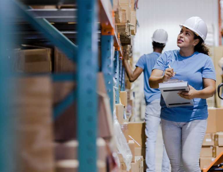 woman-in-hard-hat-with-clipboard-looking-at-boxes