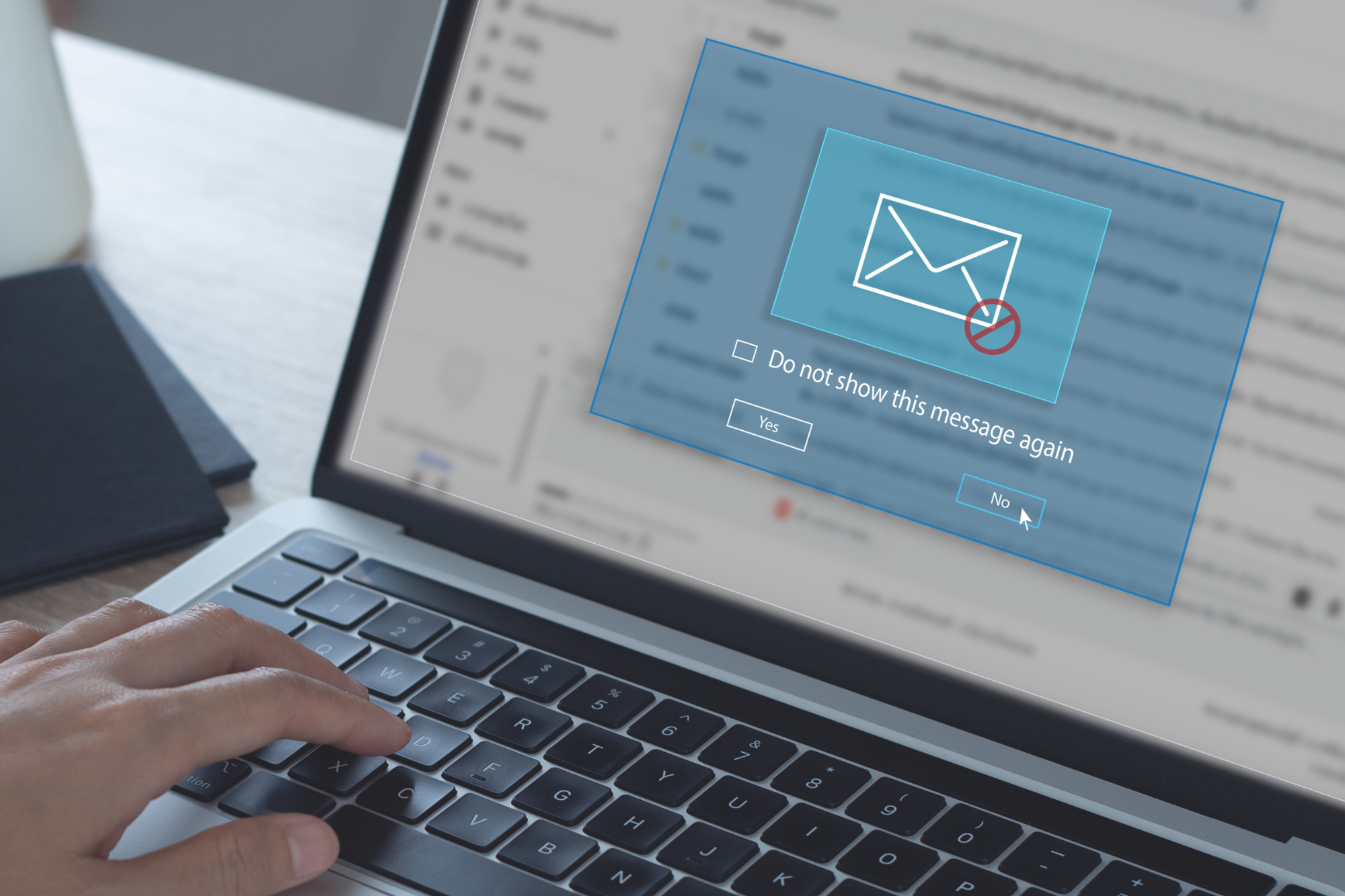 laptop with email inbox open and an email warning pop-up