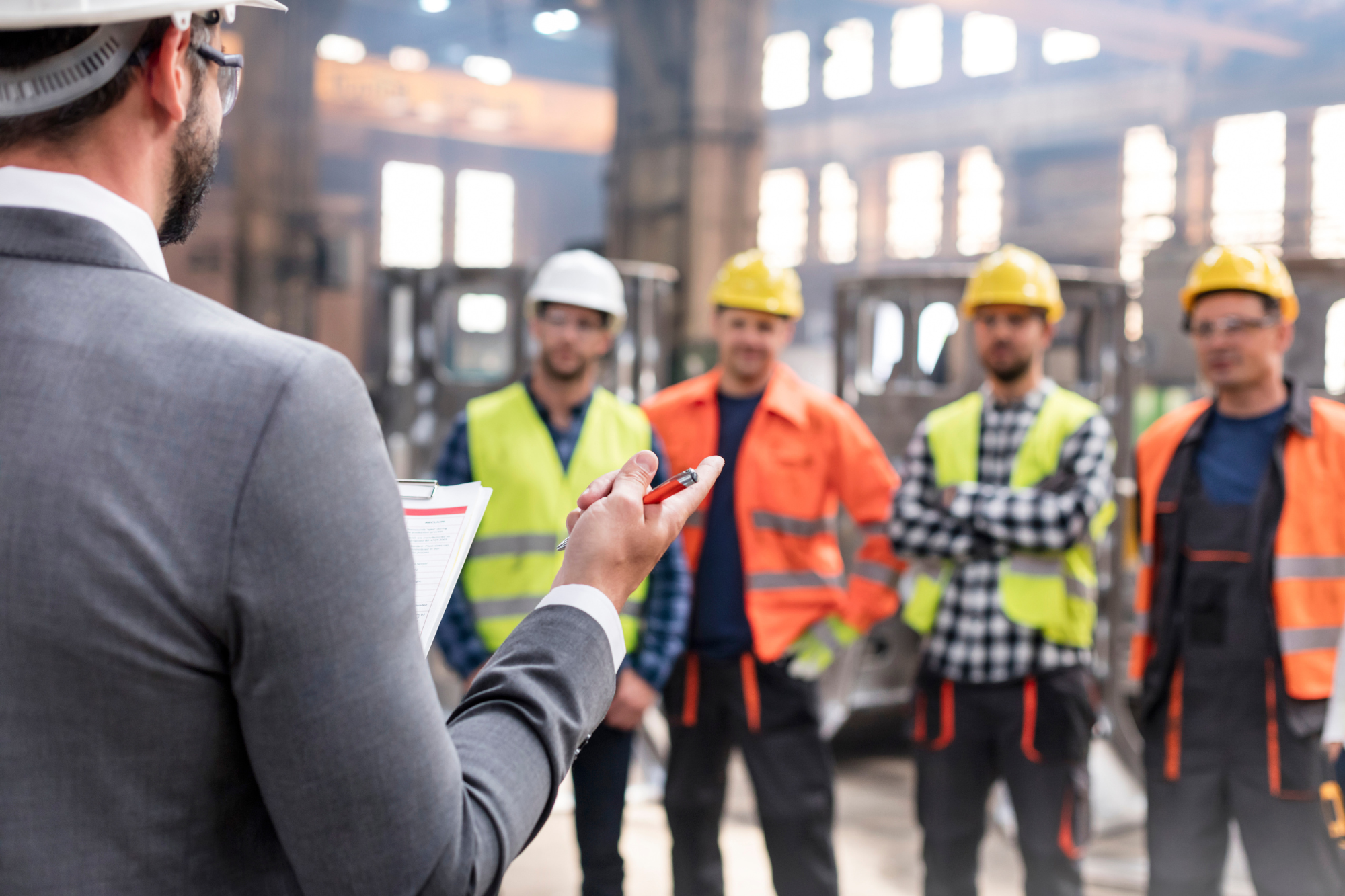 group of people in safety equipment having a safety meeting